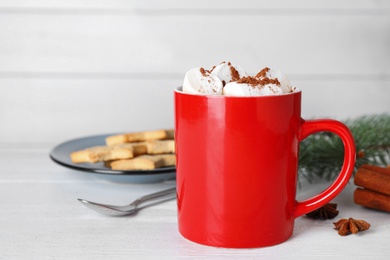Photo of Composition of tasty cocoa with marshmallows in cup on white wooden table