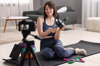 Photo of Happy sports blogger with ab roller recording fitness lesson at home