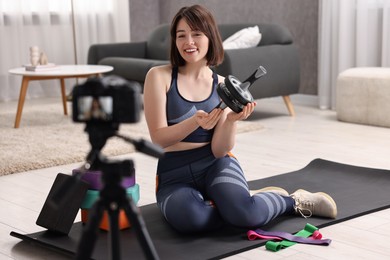 Happy sports blogger with ab roller recording fitness lesson at home