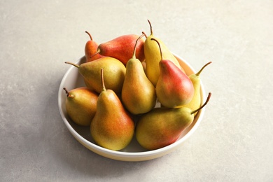 Photo of Plate with ripe pears on grey background