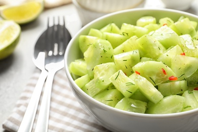 Photo of Delicious cucumber salad in bowl on table, closeup