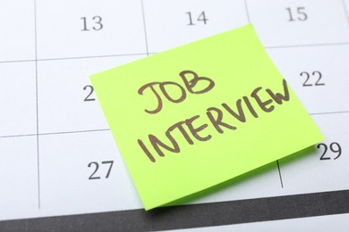 Photo of Reminder note about job interview on calendar, closeup