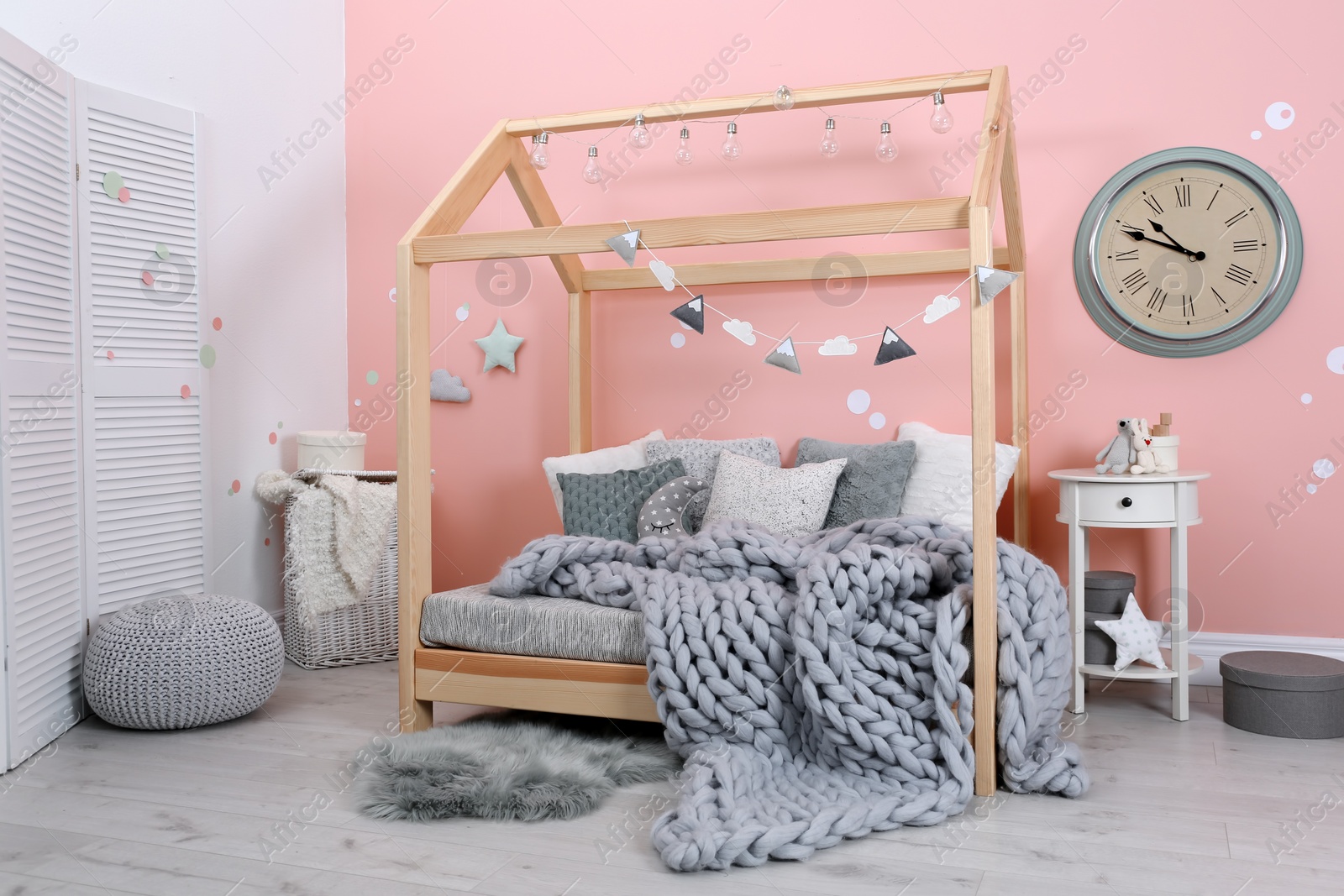 Photo of Child's room interior with comfortable bed and garland