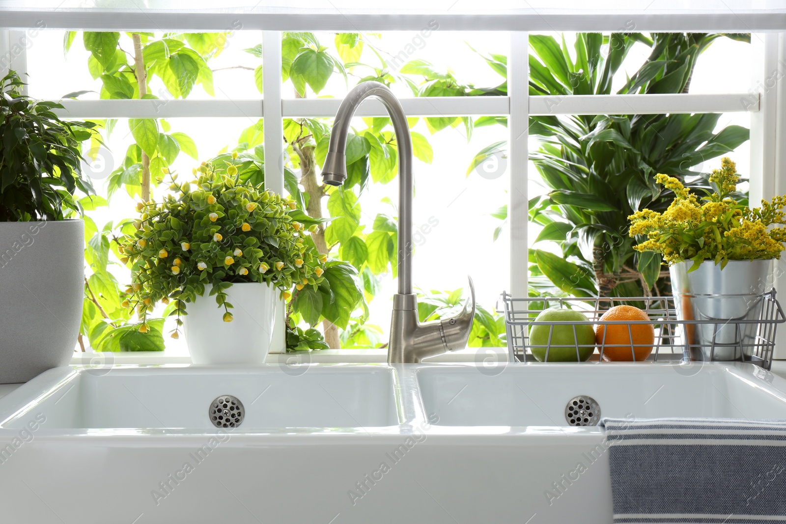 Photo of Beautiful white sink near window in modern kitchen