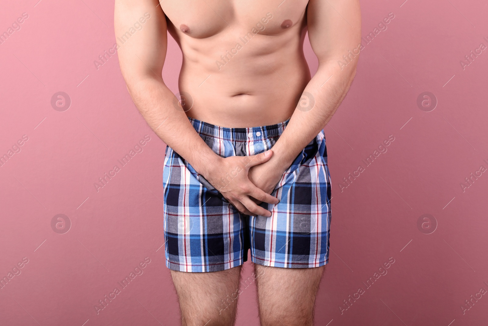 Photo of Young man with urological problems suffering from pain on color background