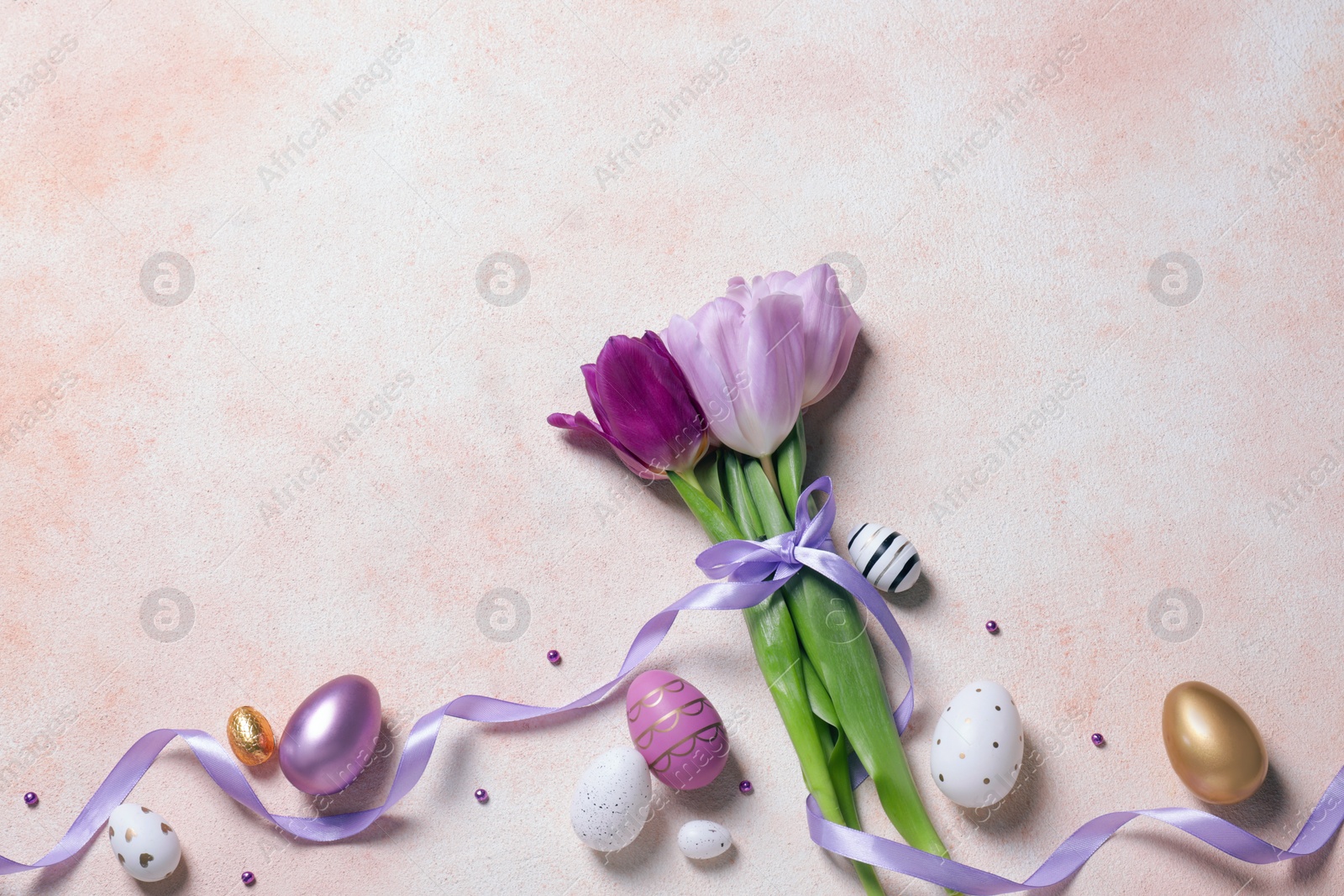 Photo of Flat lay composition with festively decorated Easter eggs and beautiful tulips on color textured background. Space for text