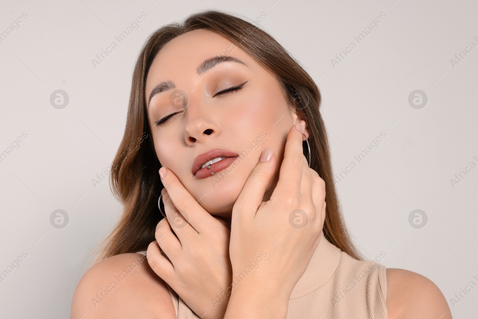 Photo of Young woman with lip piercing on white background