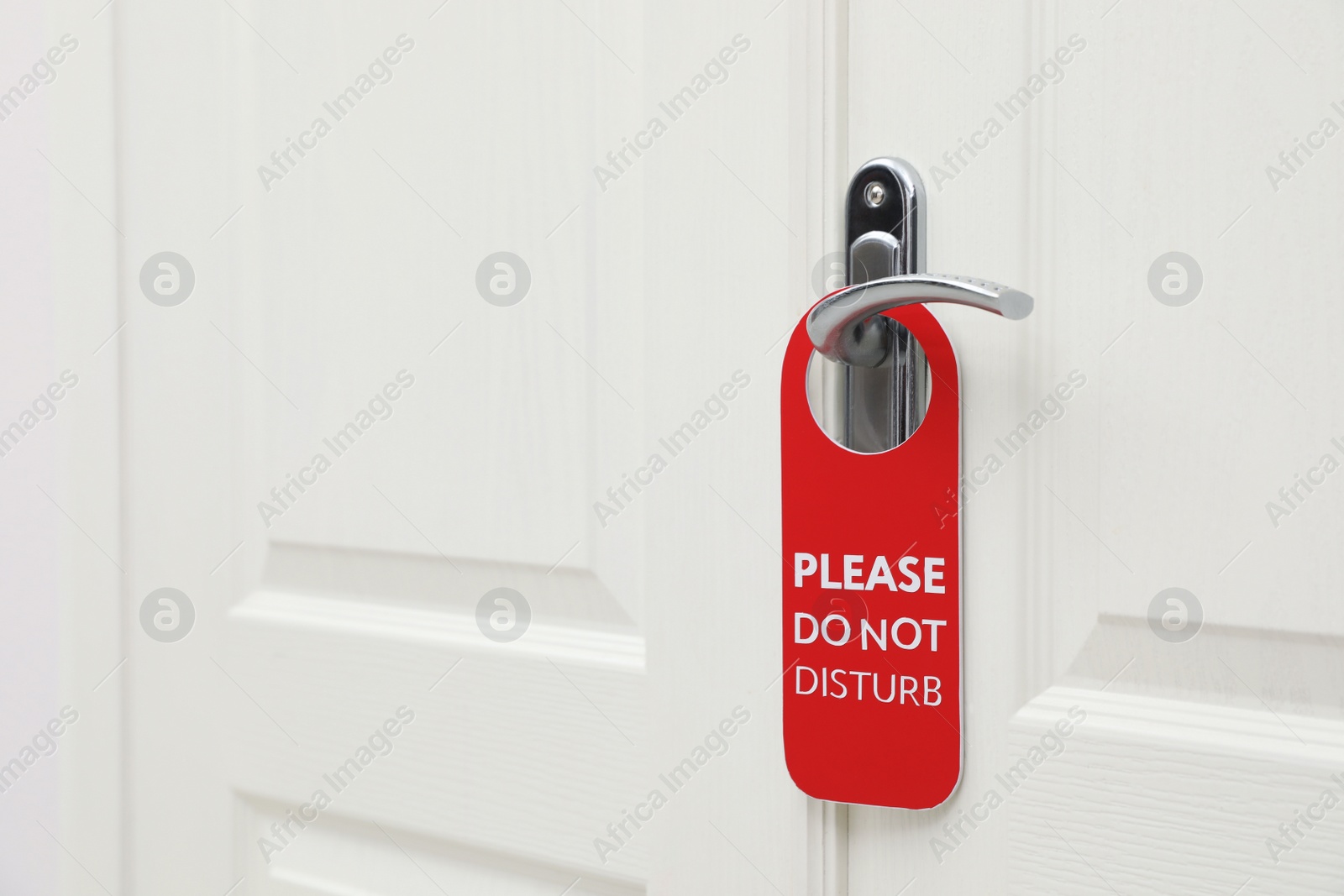 Photo of Closed door with sign PLEASE DO NOT DISTURB on handle at hotel, space for text