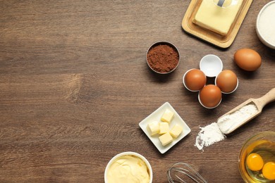 Photo of Flat lay composition with fresh butter among other products on wooden table. Space for text