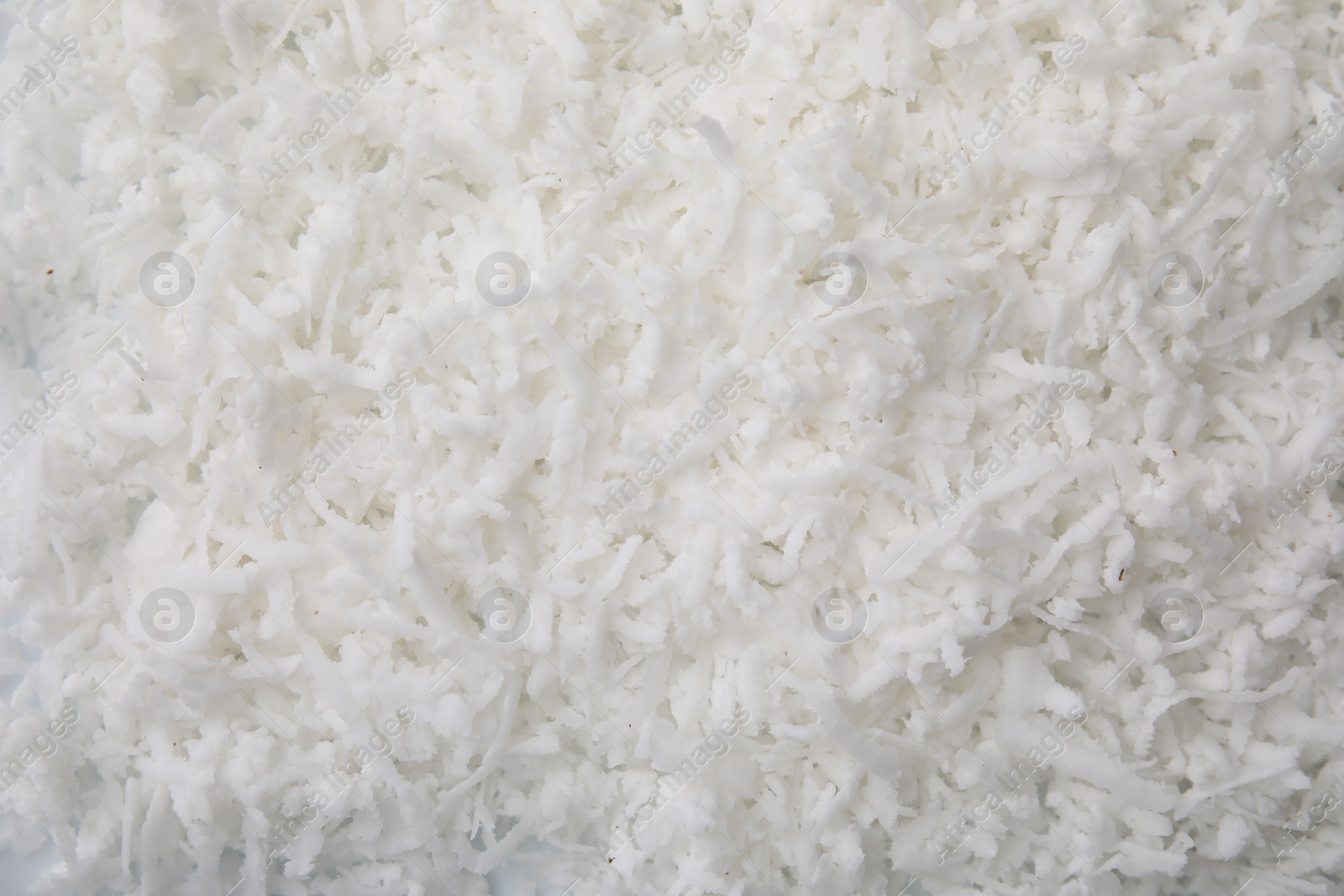 Photo of Fresh coconut flakes as background, top view