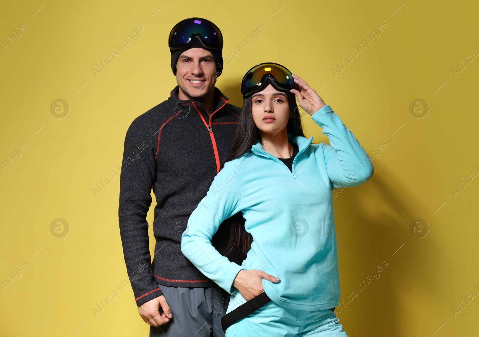 Photo of Couple wearing stylish winter sport clothes on yellow background