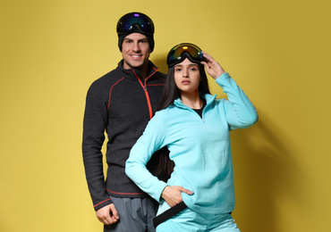 Photo of Couple wearing stylish winter sport clothes on yellow background