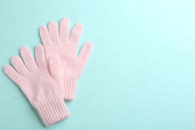 Pair of stylish woolen gloves on light blue background, flat lay. Space for text