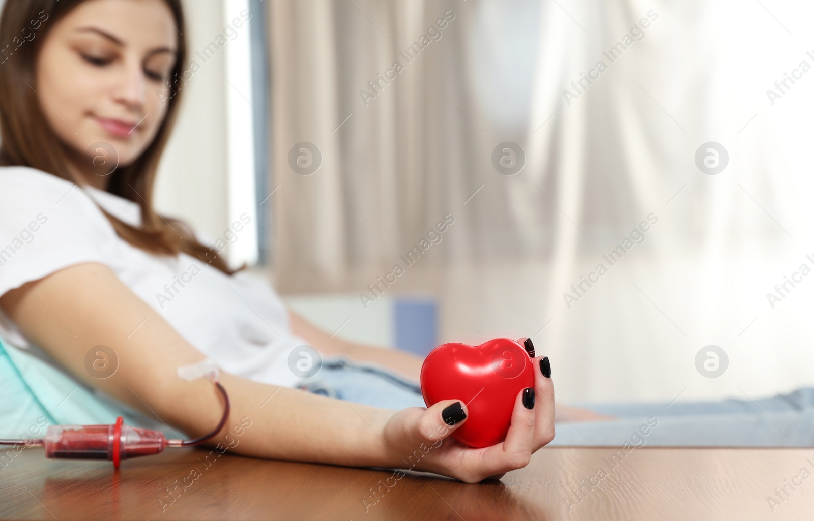 Photo of Teenager donating blood in hospital, focus on hand