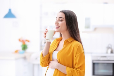 Photo of Beautiful pregnant woman drinking milk at home