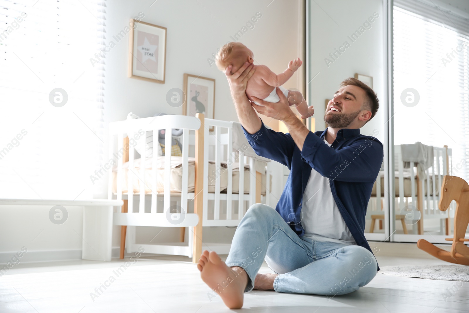 Photo of Father with his newborn son at home