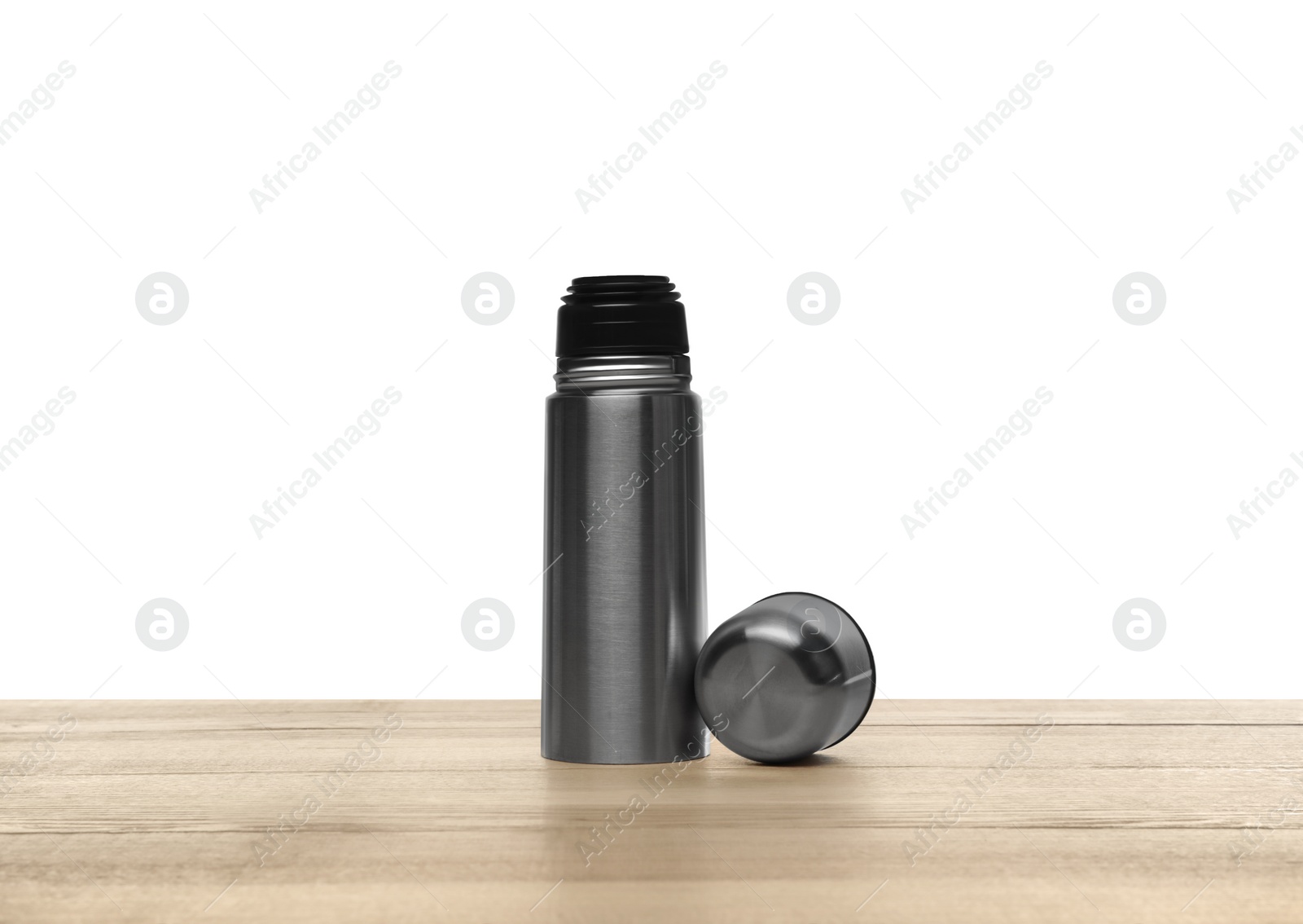 Photo of Stylish thermo bottle on wooden table against white background