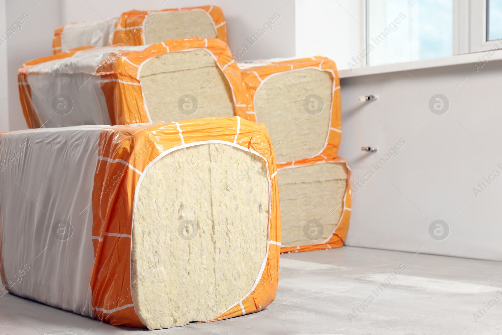 Photo of Packages of thermal insulation material in room. Space for text