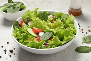 Delicious salad in bowl on light grey table, closeup