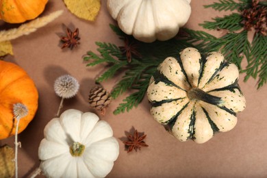 Photo of Thanksgiving day. Flat lay composition with pumpkins on light brown background