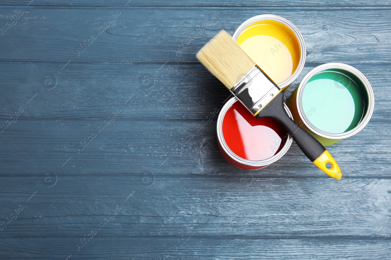 Photo of Flat lay composition with paint cans and brush on wooden background. Space for text