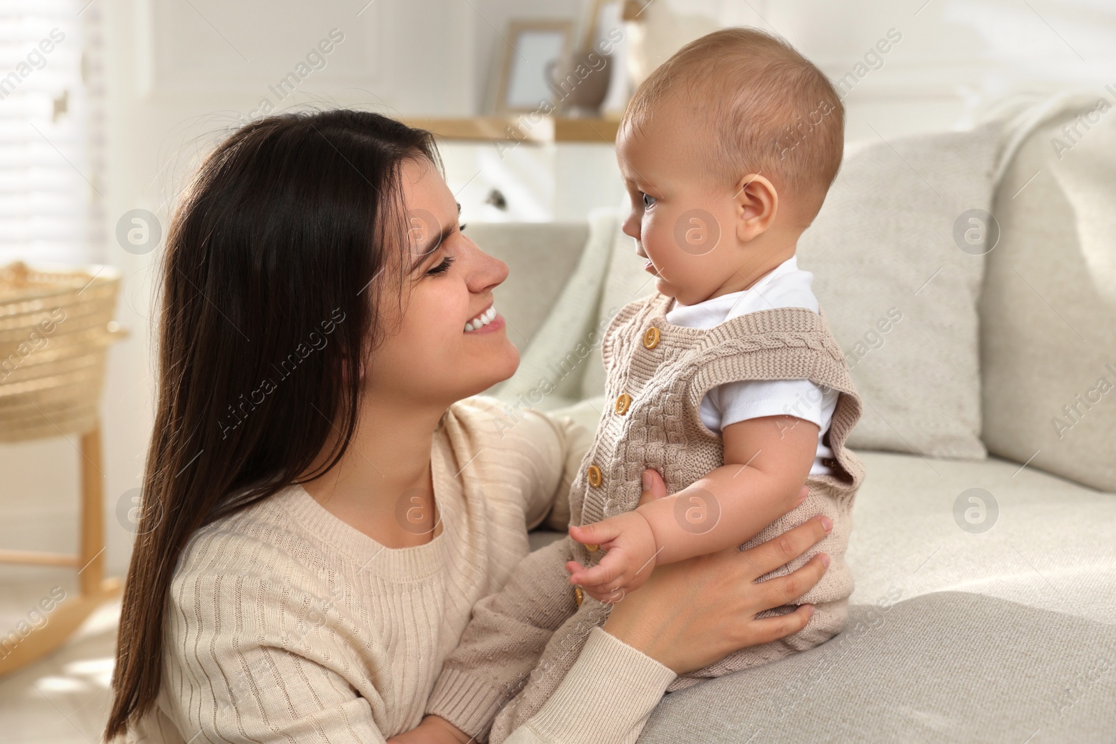 Photo of Happy young mother with her baby in living room