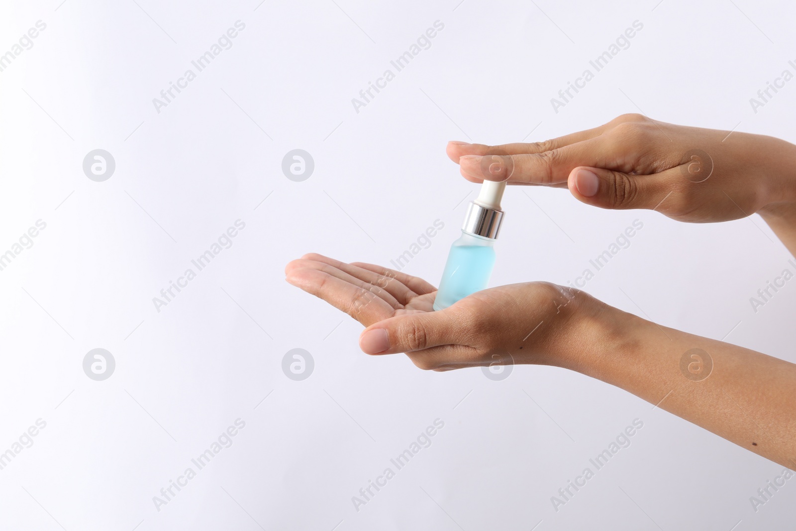 Photo of Woman with bottle of cosmetic serum on white background, closeup. Space for text