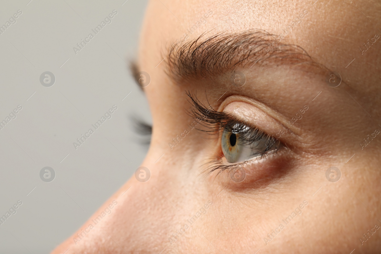 Photo of Beautiful woman with grey eye on color background, closeup