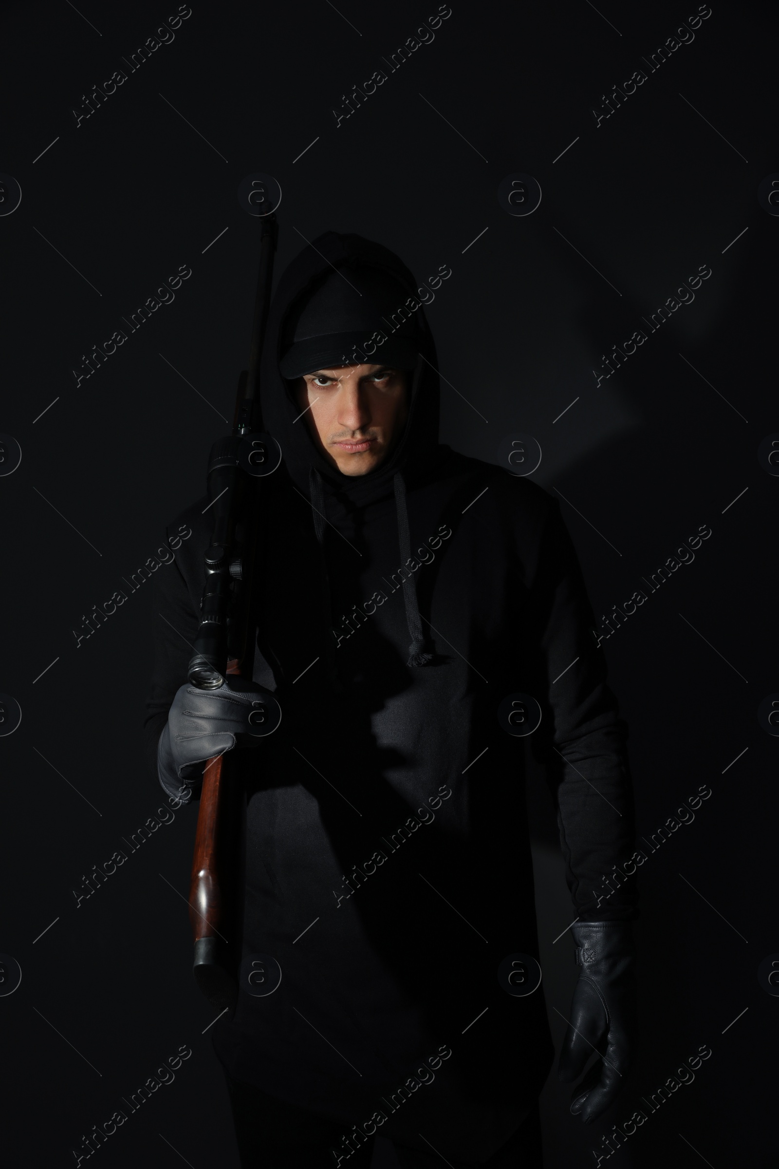 Photo of Professional killer with sniper rifle on black background