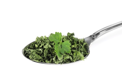 Spoon with dried parsley and fresh leaf on white background