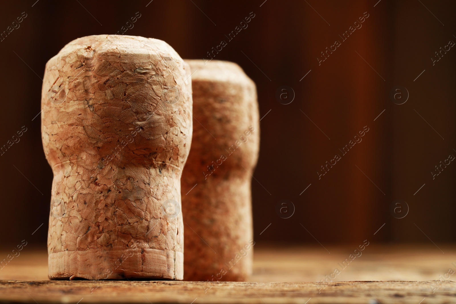 Photo of Cork of wine bottles on wooden table, closeup. Space for text