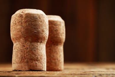 Photo of Cork of wine bottles on wooden table, closeup. Space for text