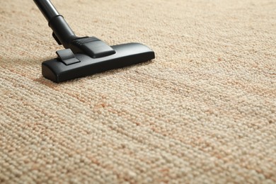 Removing dirt from beige carpet with modern vacuum cleaner. Space for text
