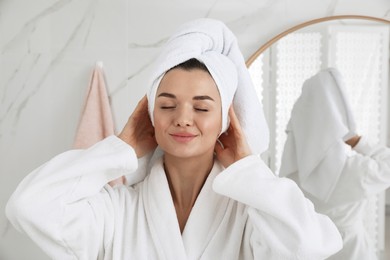 Photo of Beautiful young woman with hair wrapped in towel indoors