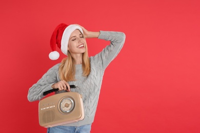 Photo of Happy woman with vintage radio on red background, space for text. Christmas music