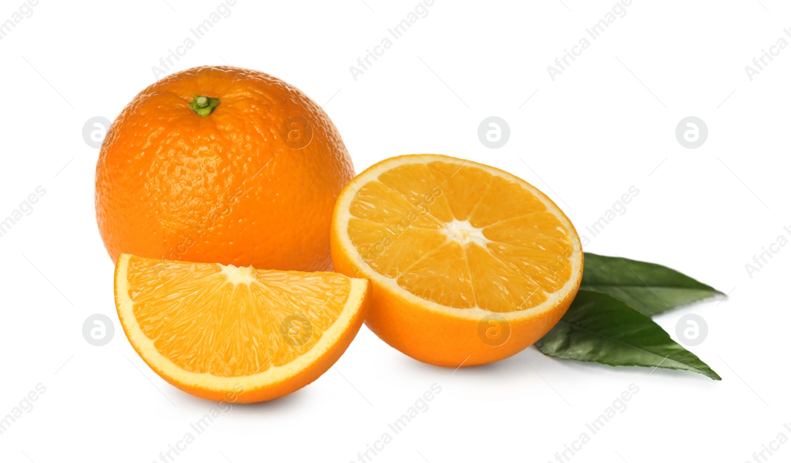 Photo of Cut and whole fresh ripe oranges with green leaves on white background