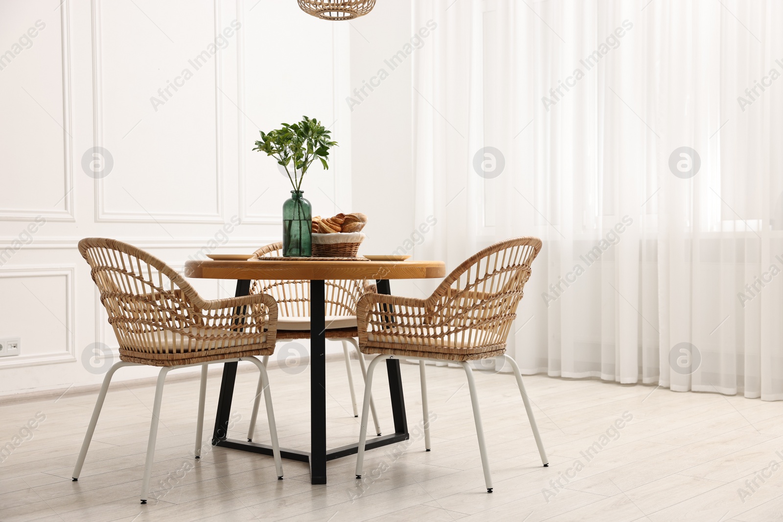 Photo of Dining room interior with comfortable furniture and green branches