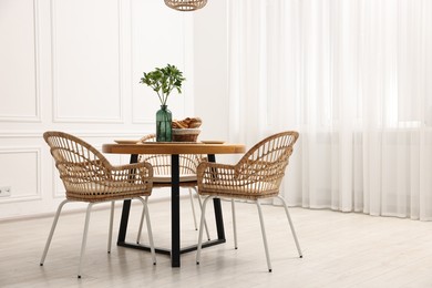 Dining room interior with comfortable furniture and green branches