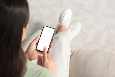 Photo of Young woman with smartphone on sofa indoors, closeup