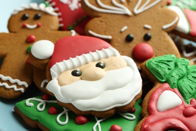 Different tasty Christmas cookies on light blue plate, closeup