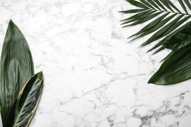 Photo of Flat lay composition with tropical leaves and space for text on marble background