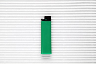 Photo of Stylish small pocket lighter on white corrugated fiberboard, top view