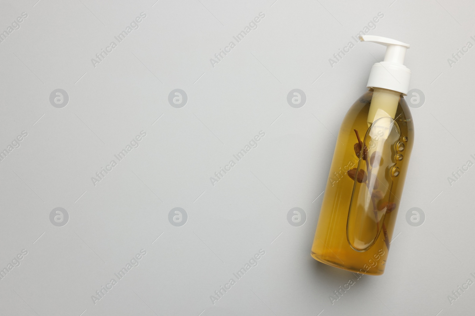 Photo of Bottle of liquid soap on light grey background, top view. Space for text