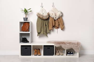 Modern hallway interior with hanging clothes and shoe rack