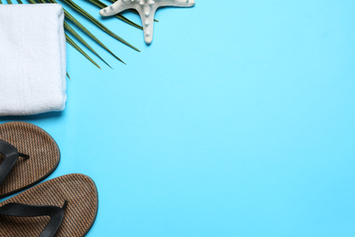 Photo of Flat lay composition with beach flip flops on light blue background. Space for text