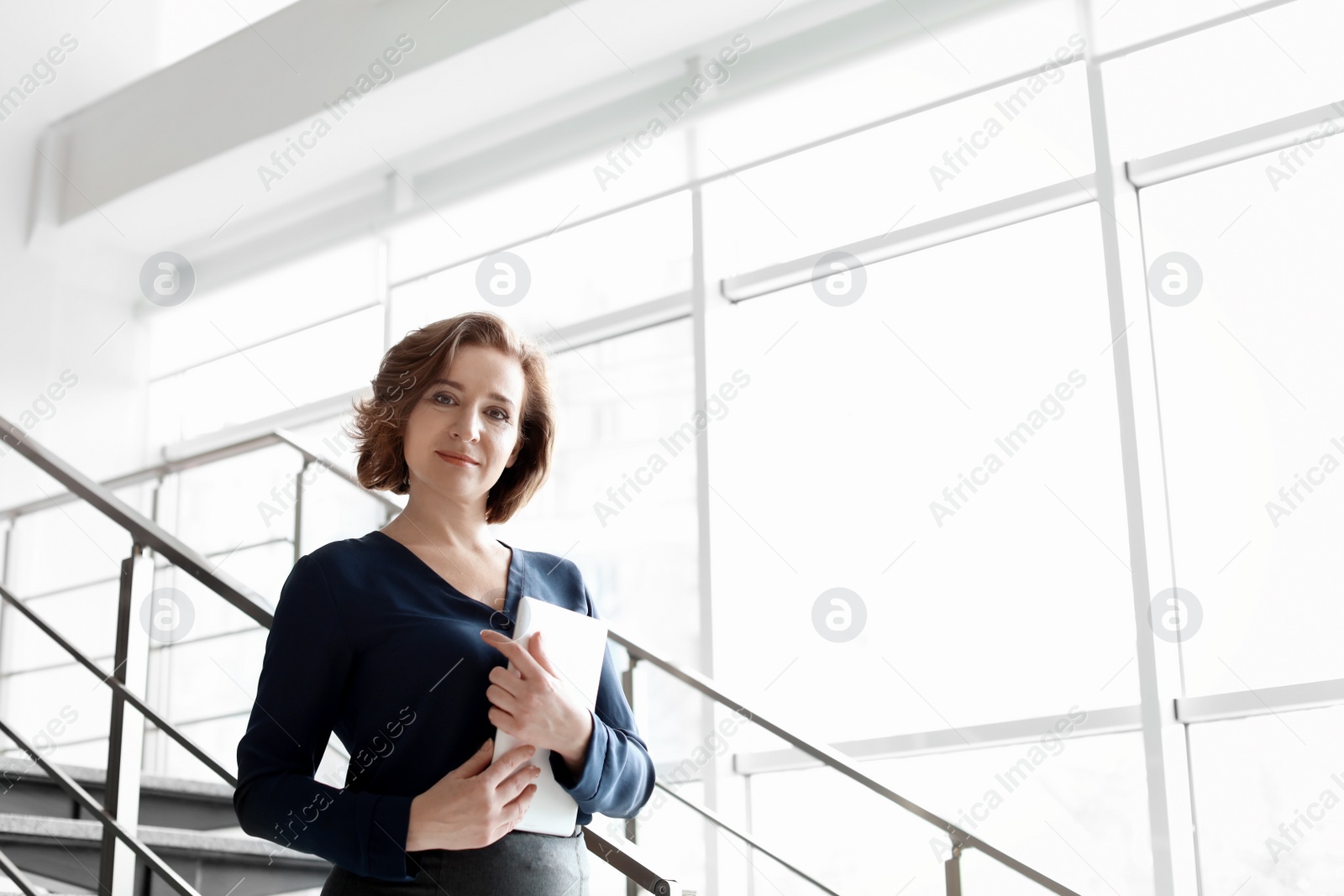 Photo of Female lawyer standing with tablet in office