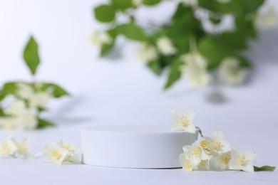 Photo of Presentation of product. Podium and beautiful jasmine flowers on white background