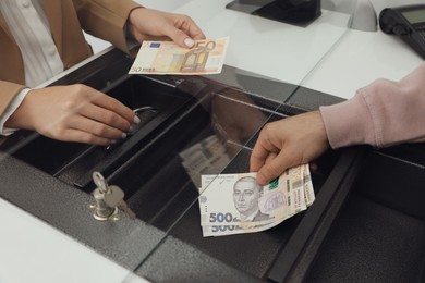 Photo of Man exchanging money at cash department window, closeup