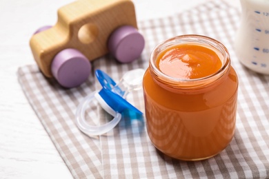Photo of Healthy baby food in jar on table, closeup. Space for text