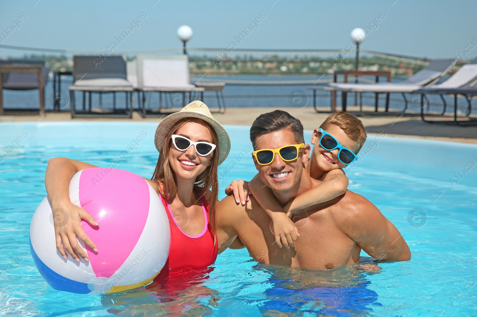 Photo of Happy family in swimming pool on sunny day